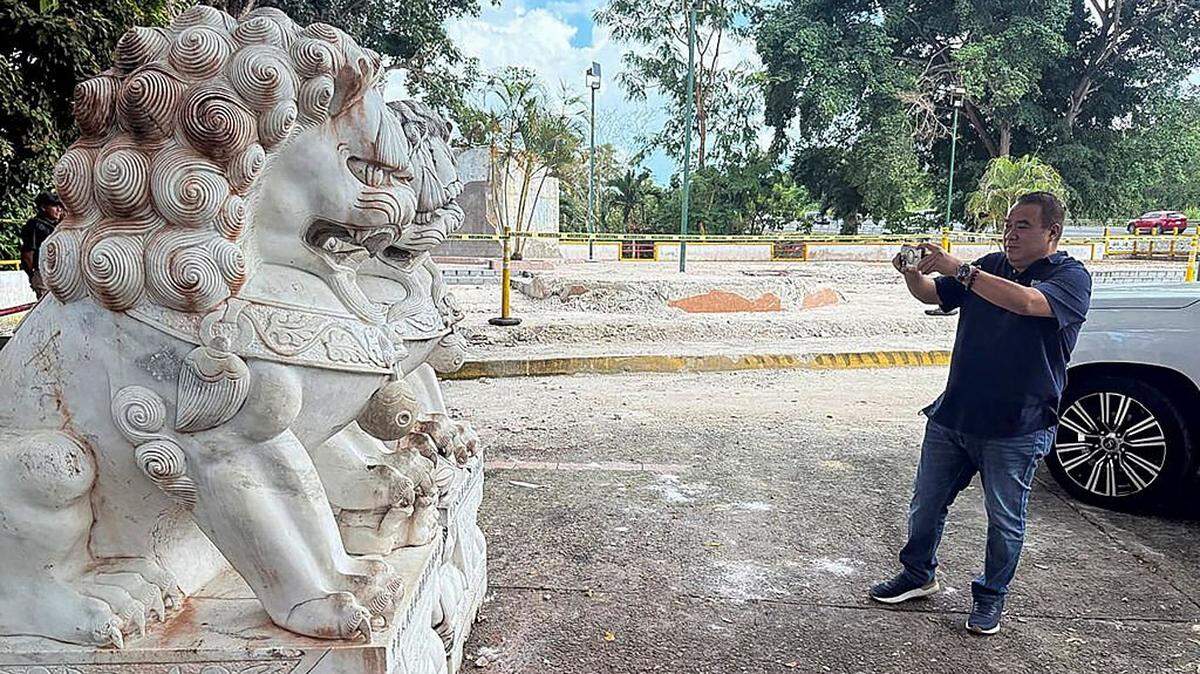 A man takes a photo with his phone of a part of the site where a Chinese monument once stood before it was demolished in Arraijan, Panama on December 28, 2025. A Chinese monument located at the entrance of the Panama Canal was demolished on December 27, 2025, night by order of a local authority, amid pressure from the US to reduce the presence of the Asian giant in the interoceanic waterway. (Photo by Daniel DE CARTERET / AFP via Getty Images)