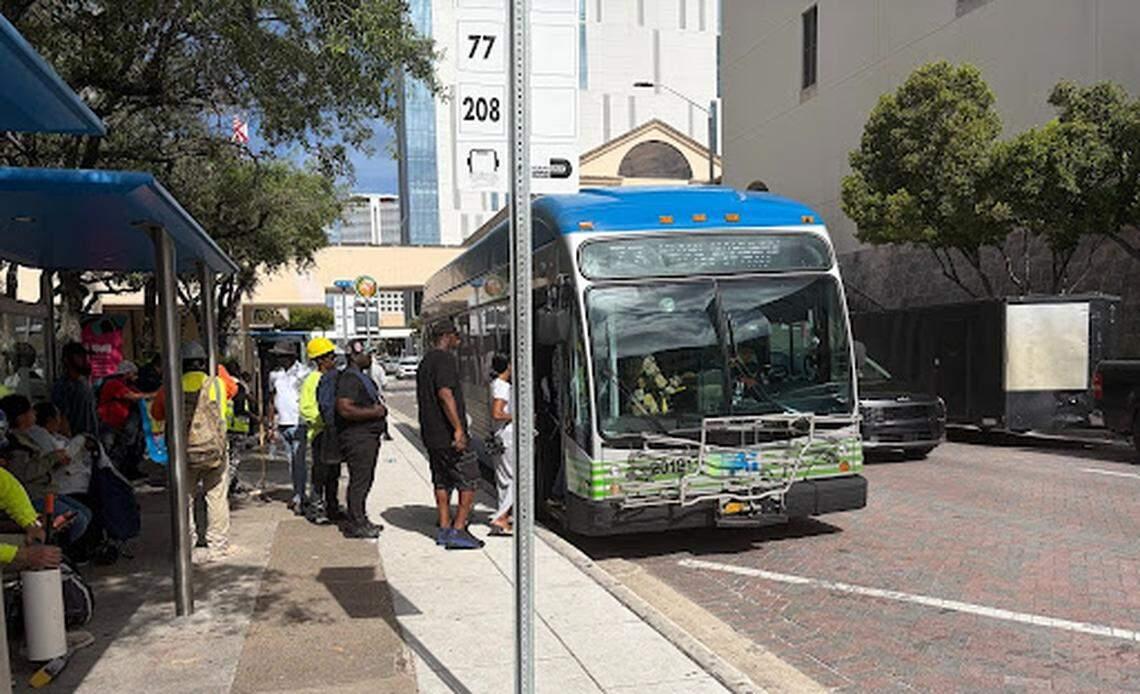 Pasajeros abordan un autobús de la Ruta 77 cerca del Government Center, en el centro de Miami, mientras otros esperan.