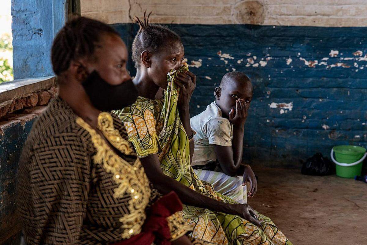 Familiares, incluido un niño, esperan a las afueras de una sala de aislamiento en el Hospital General de Mongbwalu tras haber perdido a un pariente a causa del ébola, el 22 de mayo de 2026, en Mongbwalu, República Democrática del Congo.