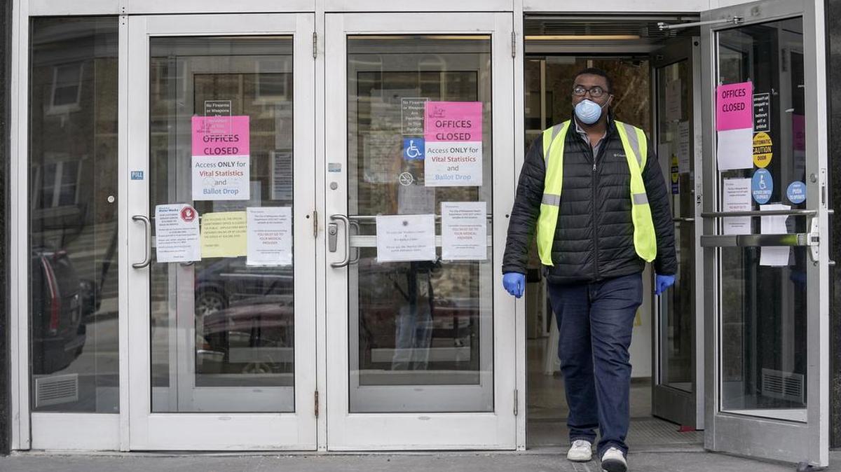 En esta fotografía de archivo del 30 de marzo de 2020, un trabajador sale del edificio municipal Frank P. Zeidler en Milwaukee. Debido a la pandemia de coronavirus, las reclamaciones de desempleo alcanzaron un máximo diario y la secretaria de salud del estado advirtió a los legisladores que las inscripciones de Medicaid estaban por aumentar drásticamente.