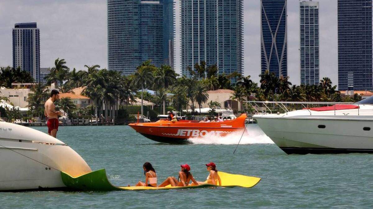 Vacacionistas disfrutan de un tiempo veraniego cerca de Monument Island.
