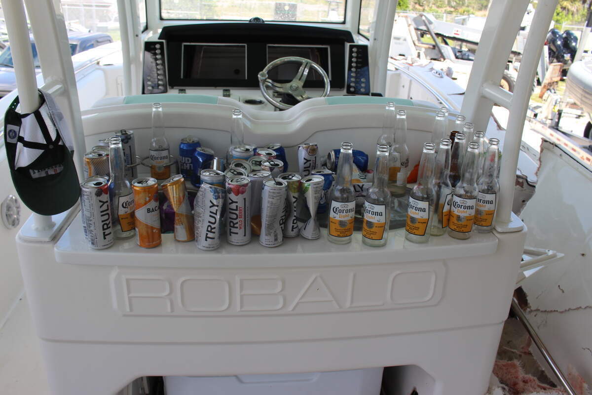 Botellas vacías de cerveza y otros envases de bebidas alcohólicas están alineados detrás de la cabina del barco Robalo de 29 pies de George Pino el 5 de septiembre de 2022. Comisión de Conservación de Pesca y Vida Silvestre de Florida.