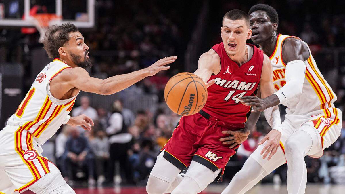 El escolta del Heat de Miami Tyler Herro (centro) trata de pasar la marca de Trae Young (izq.) y Mouhamed Gueye, de los Hawks, en el partido celebrado el 24 de febrero de 2025 en Atlanta.