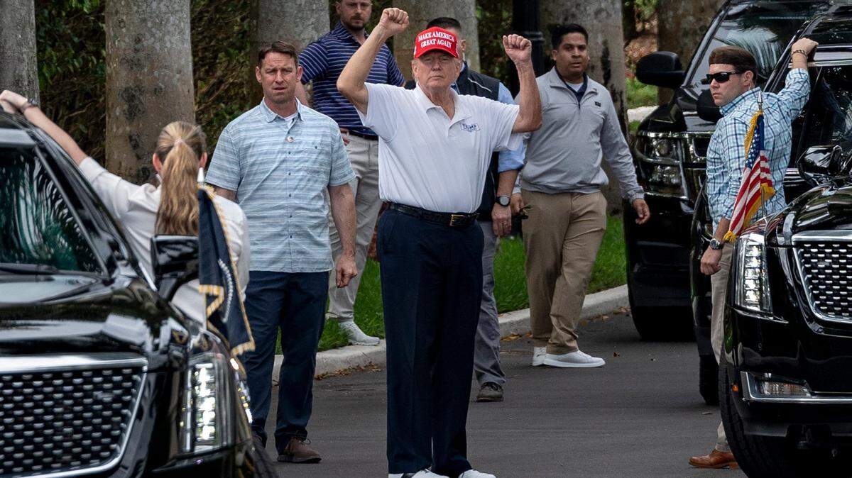 El presidente Donald Trump levanta los brazos hacia sus seguidores, quienes se reunieron al otro lado de la calle del Trump International Golf Club para celebrar el Día de los Presidentes en West Palm Beach, Florida, el 17 de febrero de 2025.
