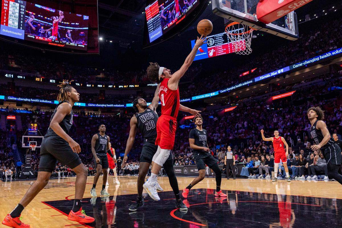 El jugador del Heat Jaime Jáquez Jr. (11) tira al aro ante la marca de Day’Ron Sharpe (20), de los Nets de Brooklyn, en el partido celebrado el 23 de diciembre de 2024 en Miami.