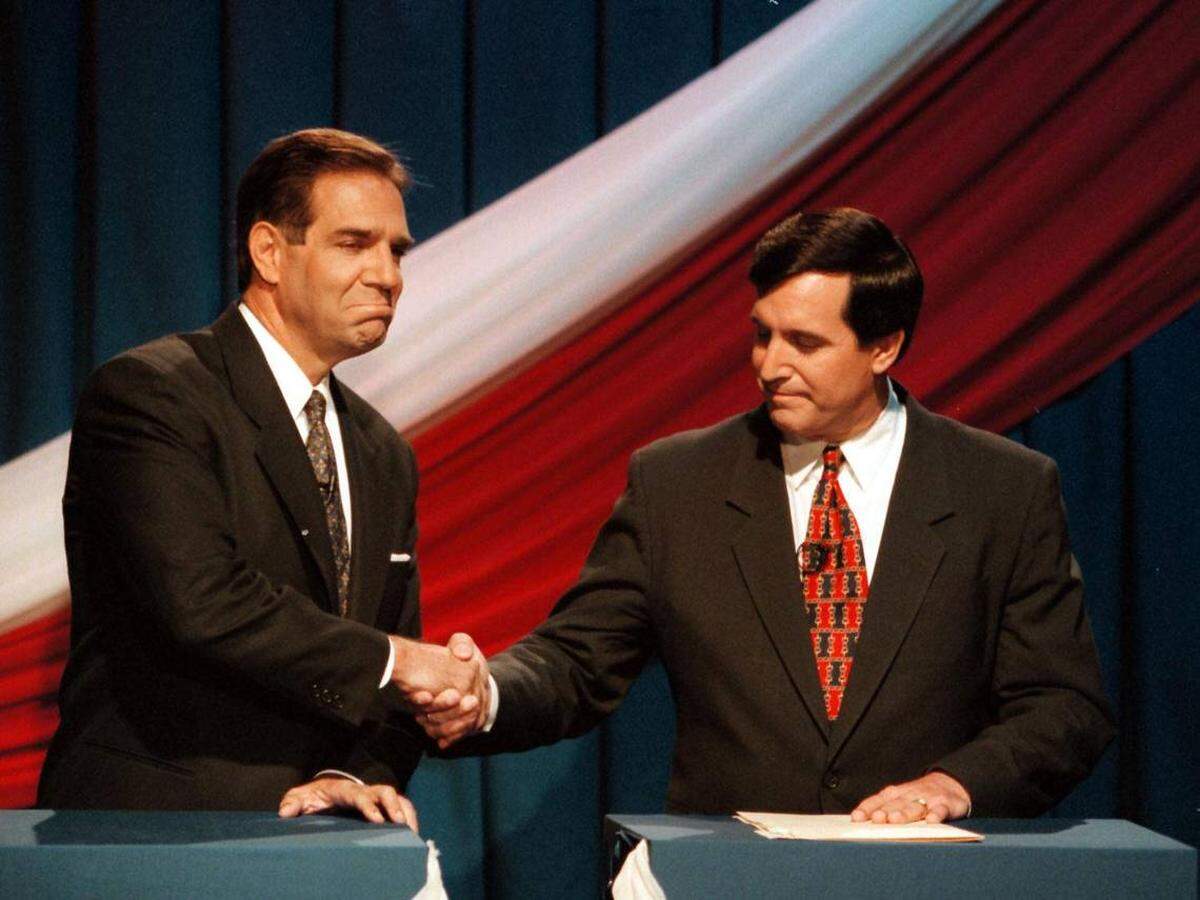 En esta foto del 24 de octubre de 1997, los dos principales candidatos a la alcaldía de Miami, Xavier Suárez (izquierda) y Joe Carollo (derecha), se dan la mano mientras evitan la mirada. 