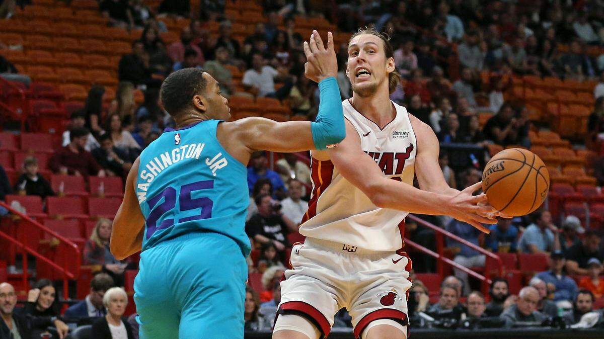 El jugador del Heat Kelly Olynyk (der.) pasa la pelota ante la marca de PJ Washington, de los Hornets, en el partido celebrado el 25 de noviembre de 2019 en Miami.