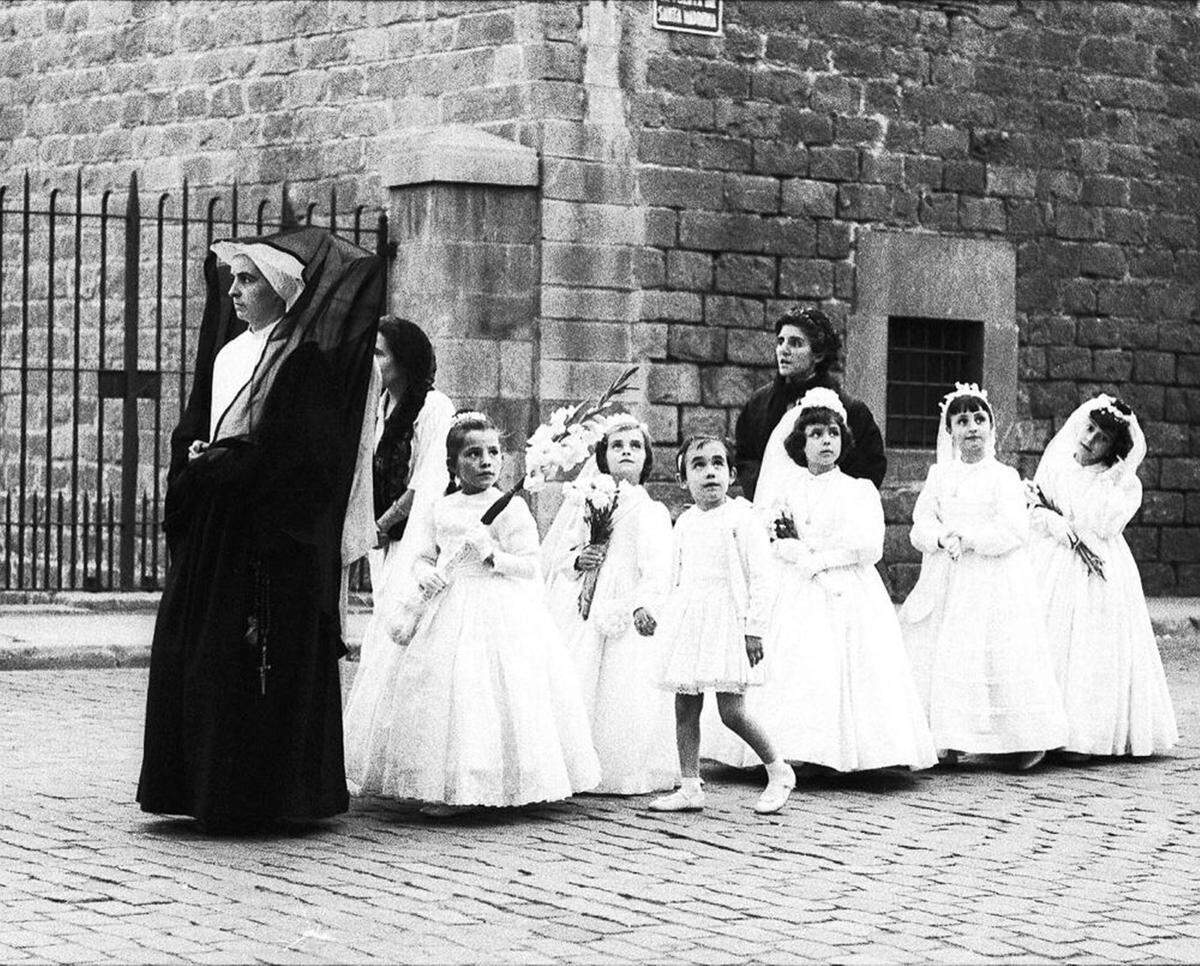 A choir of girls leaves the Colegio La Inmaculada, led by one of the Daughters of Charity.