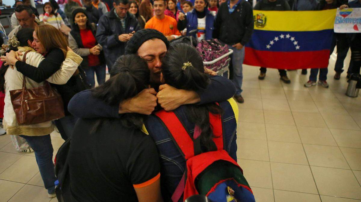 Migrantes venezolanos abrazan a sus familiares al llegar a una terminal de autobuses en el norte de Lima el 26 de agosto del 2018.