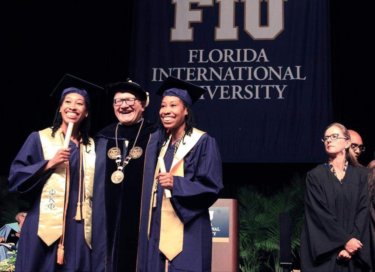 Foto de archivo de Shonda y Shalisha Witherspoon, gemelas idénticas que se graduaron de Universidad Internacional de Florida con títulos en Tecnología de la Información y el promedio más alto (3.95) en la Facultad de Ingeniería y Ciencias de la Computación, posan con el Mark Rosenberg, presidente de FIU, después de recibir sus diplomas, el 9 de mayo de 2016.