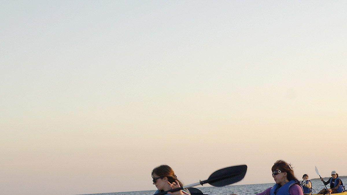 Blaire Briody y Erika Roman reman durante un recorrido en kayak al atardecer en el Crandon Park de Key Biscayne.