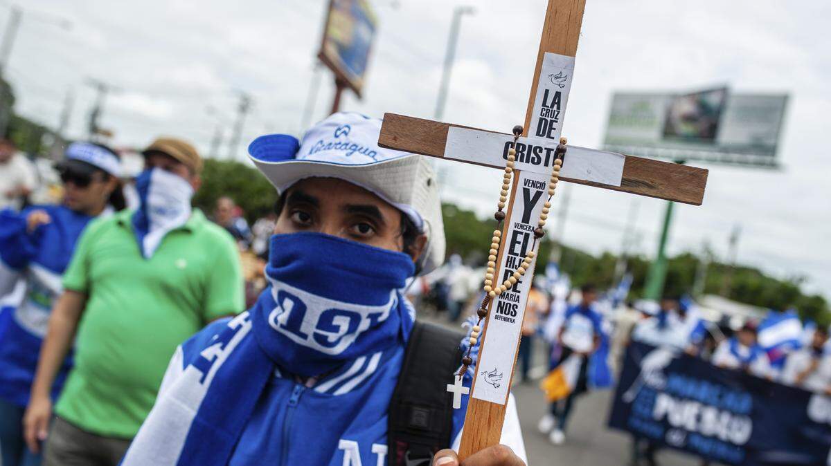 Un manifestante marcha con un crucifijo en una protesta contra Daniel Ortega el 21 de julio en Managua.
