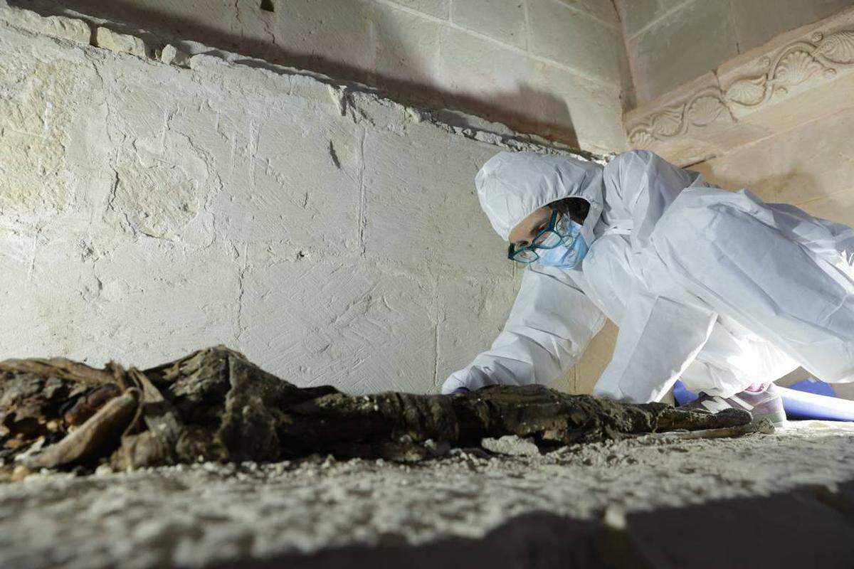 Un arqueólogo estudia los restos de 600 años que se hallaron en un sarcófago.