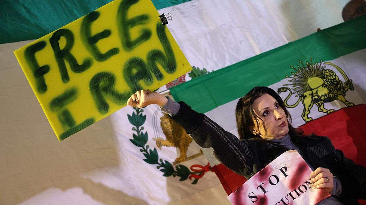 Una mujer sostiene dos carteles que dicen “Libertad para Irán” y “Detengan las ejecuciones”, con la bandera del país antes de la revolución islámica de 1979, durante una protesta en solidaridad con los manifestantes iraníes, en Holon, Israel, el sábado 24 de enero de 2026.