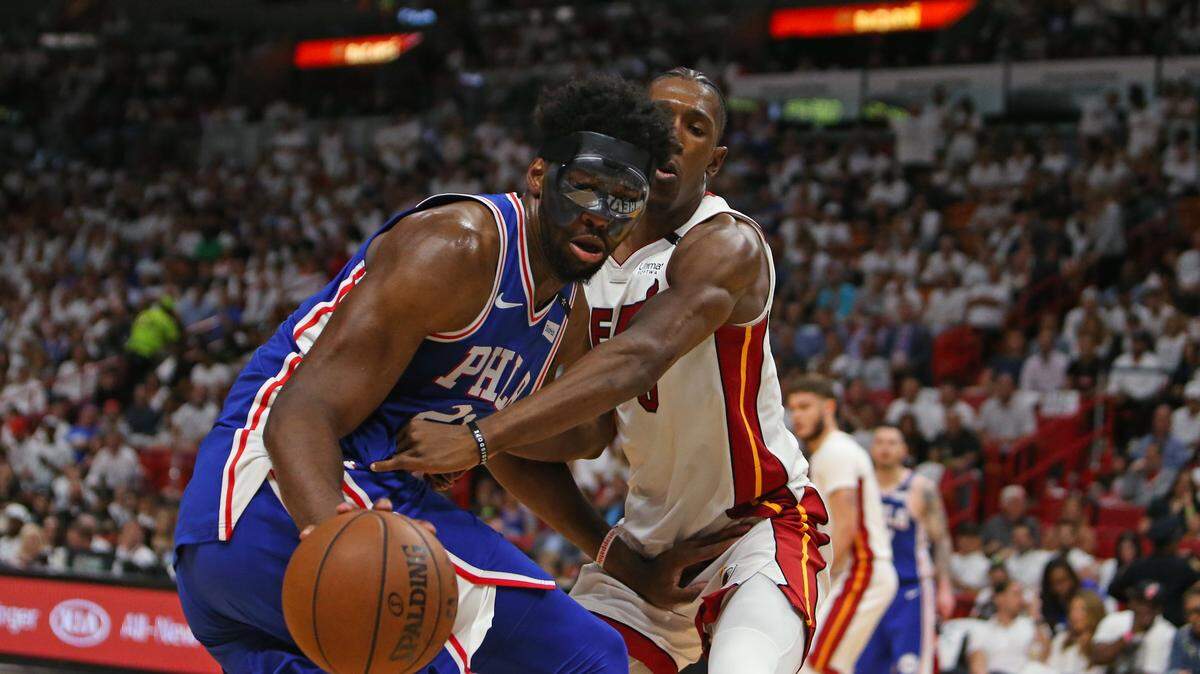 El jugador del Heat Josh Richardson (der.) trata de robarle el balón a Joel Embiid, de Filadelfia, en el partido efectuado el 19 de abril de 2018 en Miami.
