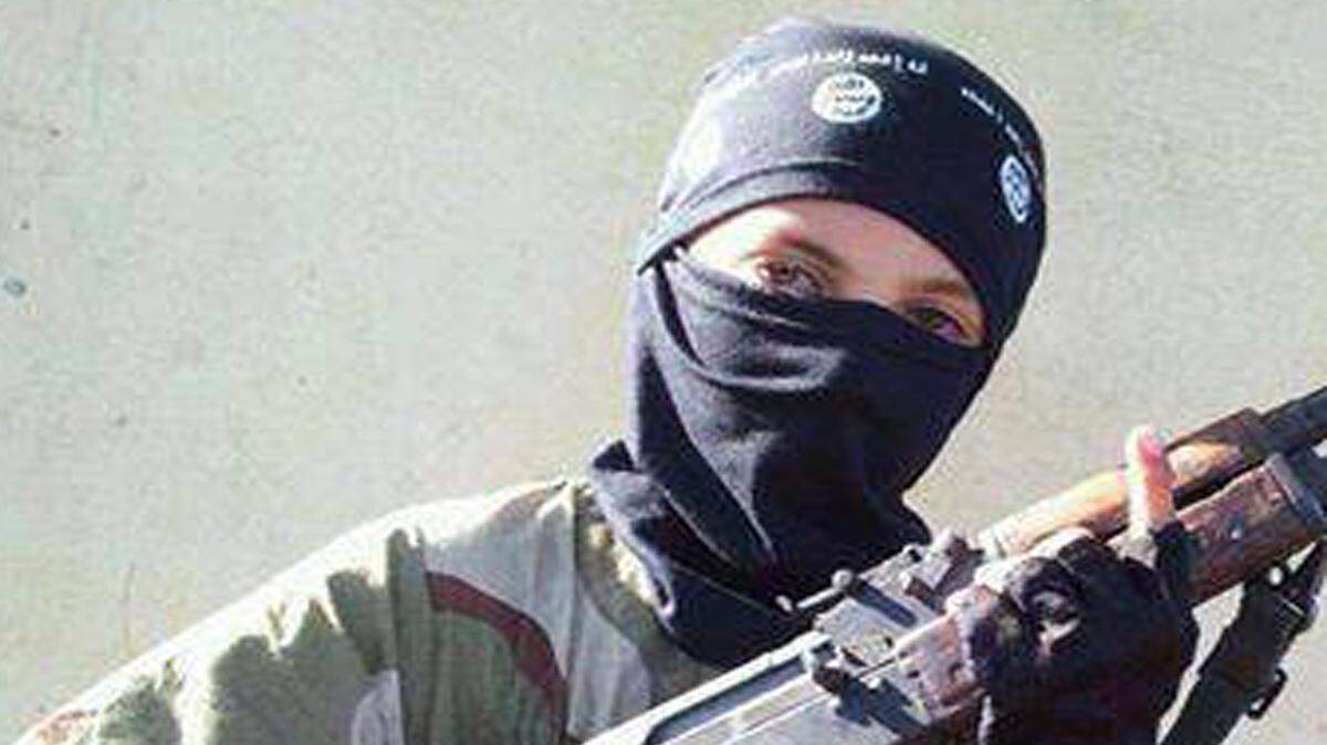 En esta imagen sin fecha, publicada en línea y disponible el jueves, 20 de noviembre 2014, un niño que llevaba un sombrero con el logotipo del grupo Estado Islámico posa con un arma en Raqqa, Siria. 