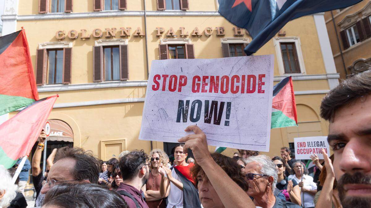 Un manifestante sostiene un cartel que dice “Detengan el genocidio ahora” durante una conferencia de prensa para denunciar los ataques con drones que sufrió la flotilla Global Sumud, en Montecitorio, Italia, el miércoles, 24 de septiembre de 2025. La flotillla intenta entregar ayuda humanitaria para los palestinos en Gaza.