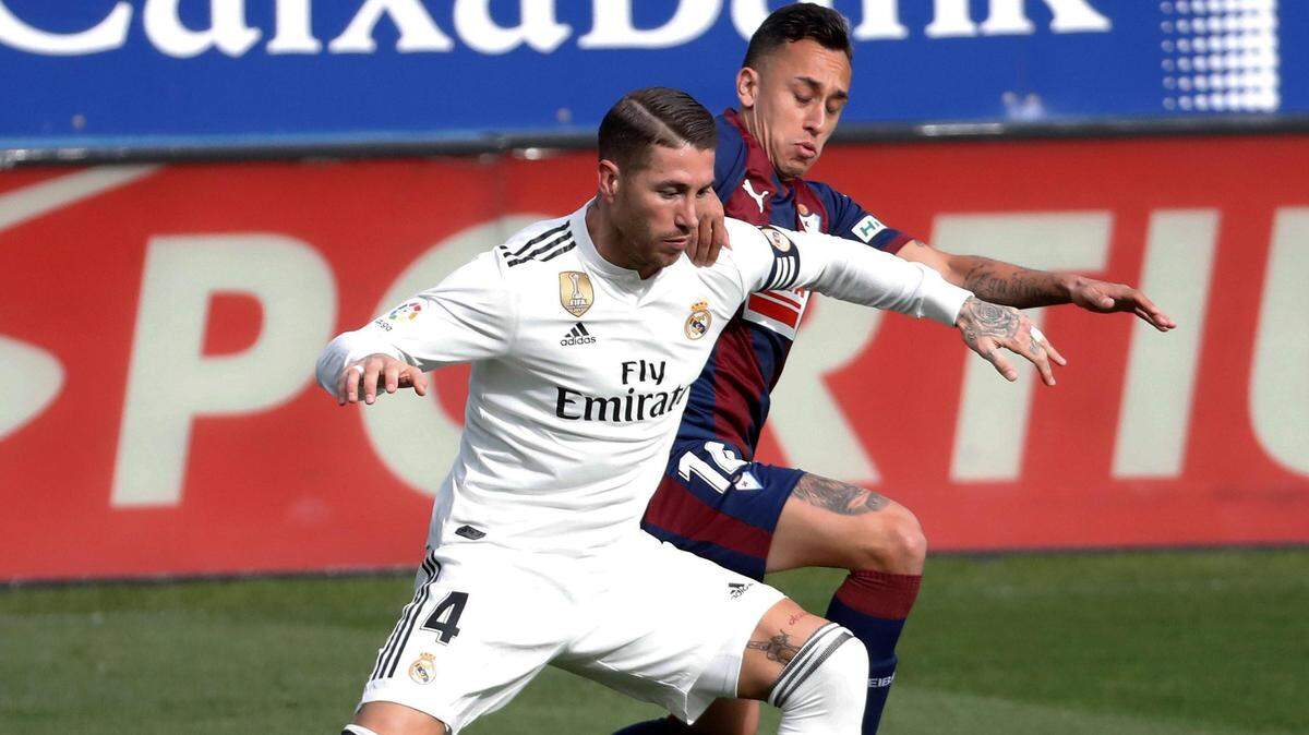 El centrocampista del Eibar, Fabián Orellana (der.), lucha un balón con el defensa del Real Madrid, Sergio Ramos, durante el partido de la jornada 13 de LaLiga Santander celebrado el 24 de noviembre de 2018.