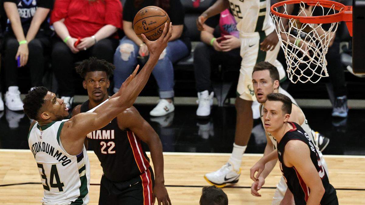 El delantero de poder de los Bucks Giannis Antetokounmpo (34) va a la canasta ante el delantero del Heat Jimmy Butler (22) en el Juego 3 de su serie de playoffs de primera ronda de la NBA el jueves 27 de mayo de 2021 en el AmericanAirlines Arena en Miami.
