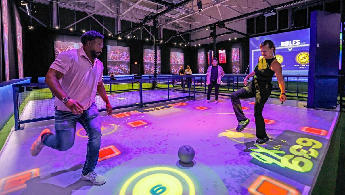 Venue managers, Jonathan Ayi and Julie Arias, play soccer at the Messi Experience. 360 degree projection mapping, 3D visuals, video and artificial intelligence combine to create an immersive experience into Messi’s life and career during The Messi Experience inside The Hangar at Regatta Grove in Miami, Florida on Wednesday, April 24, 2024