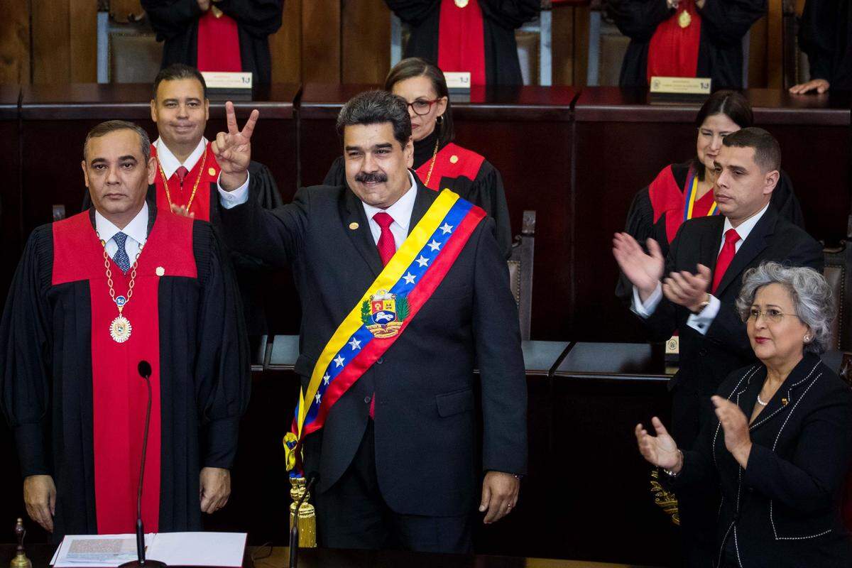 El presidente de Venezuela, Nicolás Maduro, reacciona luego de jurar como presidente para un segundo período de gobierno que lo mantendrá en el poder hasta el año 2025, ante el presidente del Tribunal Supremo de Justicia (TSJ), Maikel Moreno (i), durante una ceremonia este jueves 10 de enero de 2019, en Caracas.