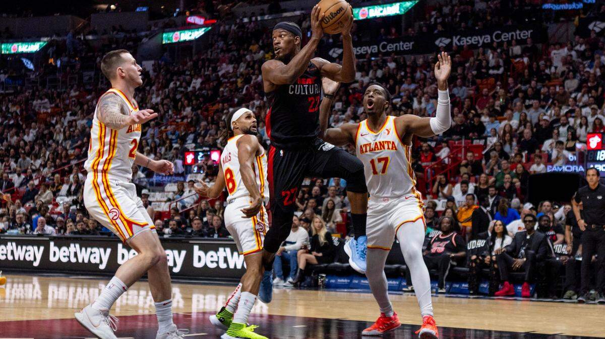 El delantero del Miami Heat Jimmy Butler (22) busca el pase de salida mientras lo defienden el delantero de los Atlanta Hawks Onyeka Okongwu (17) y el guardia Garrison Mathews (25) durante el primer cuarto de un partido de la NBA en el Kaseya Center de Miami, Florida, el viernes. 19 de enero de 2024.