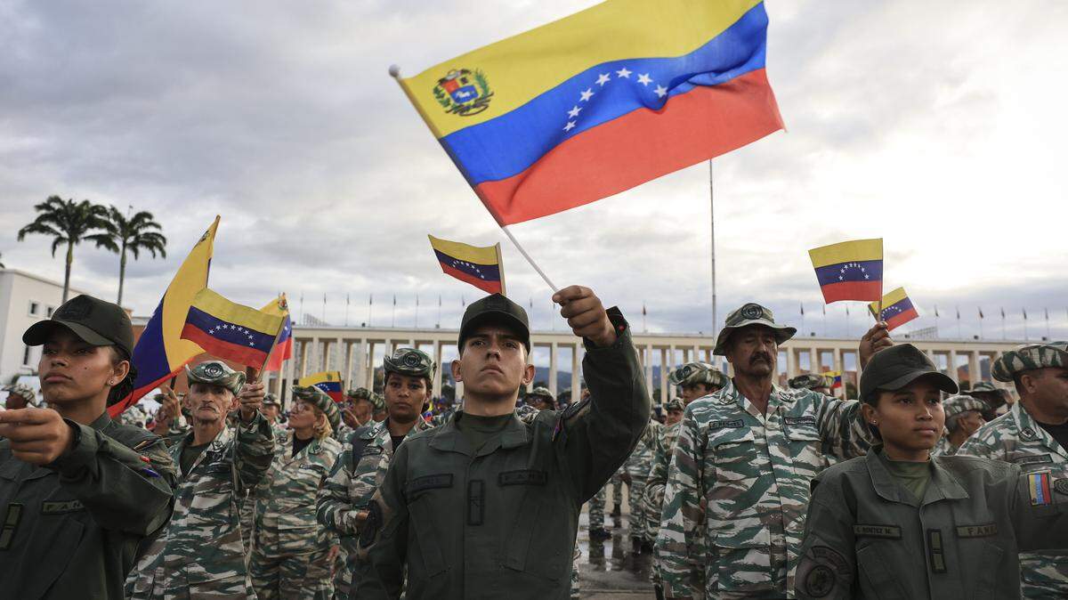 CARACAS, VENEZUELA - NOVEMBER 25: Members of the Bolivarian National Armed Forces (FANB) wave Venezuelan flags during a military ceremony commemorating the 200th anniversary of the presentation of the 'Sword of Peru' to Venezuelan independence hero SimÃ³n BolÃvar on November 25, 2025, in Caracas, Venezuela. The United States recently designated the "Cartel De Los Soles" (Cartel of The Suns) as a foreign terrorist organization, a group allegedly led by the president of Venezuela, Nicolas Maduro, and which, it is presumed, includes high-ranking members of the Venezuelan government. (Photo by Jesus Vargas/Getty Images)