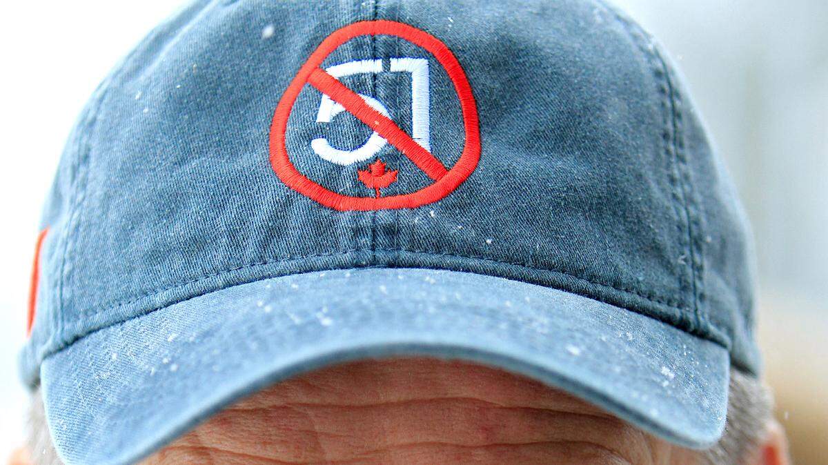 Michael Baeumler, dueño y director ejecutivo de Bastard Clothing & Apparel Limited, usa una de las gorras que rechazan que Canadá se convierta en el estado 51 de Estados Unidos, durante una protesta en Brampton, Ontario, el sábado 15 de febrero de 2025.