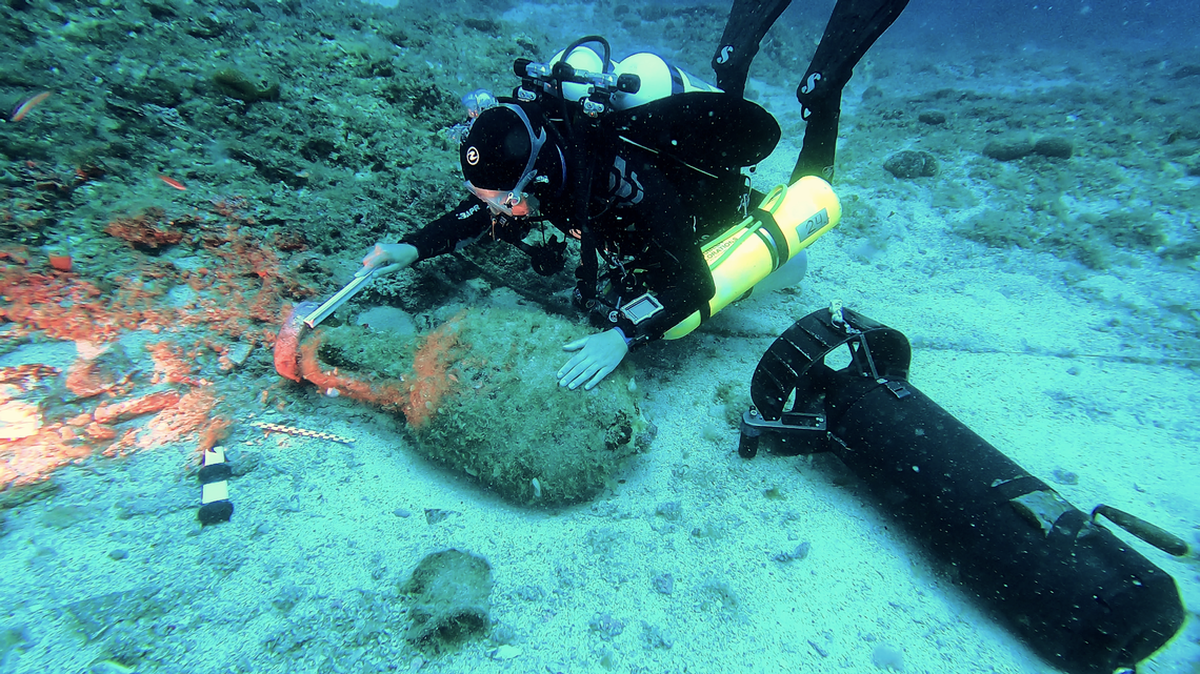 Un experto en arqueología marina examina un gran recipiente de cerámica hallado en el naufragio de Anticitera, en Grecia.