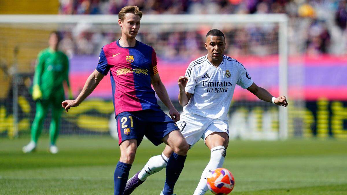 El jugador de Barcelona Frenkie de Jong (izq.) lucha por la pelota con Kylian Mbappé, del Real Madrid, en el partido de la liga española celebrado el 11 de mayo de 2025 en Barcelona.