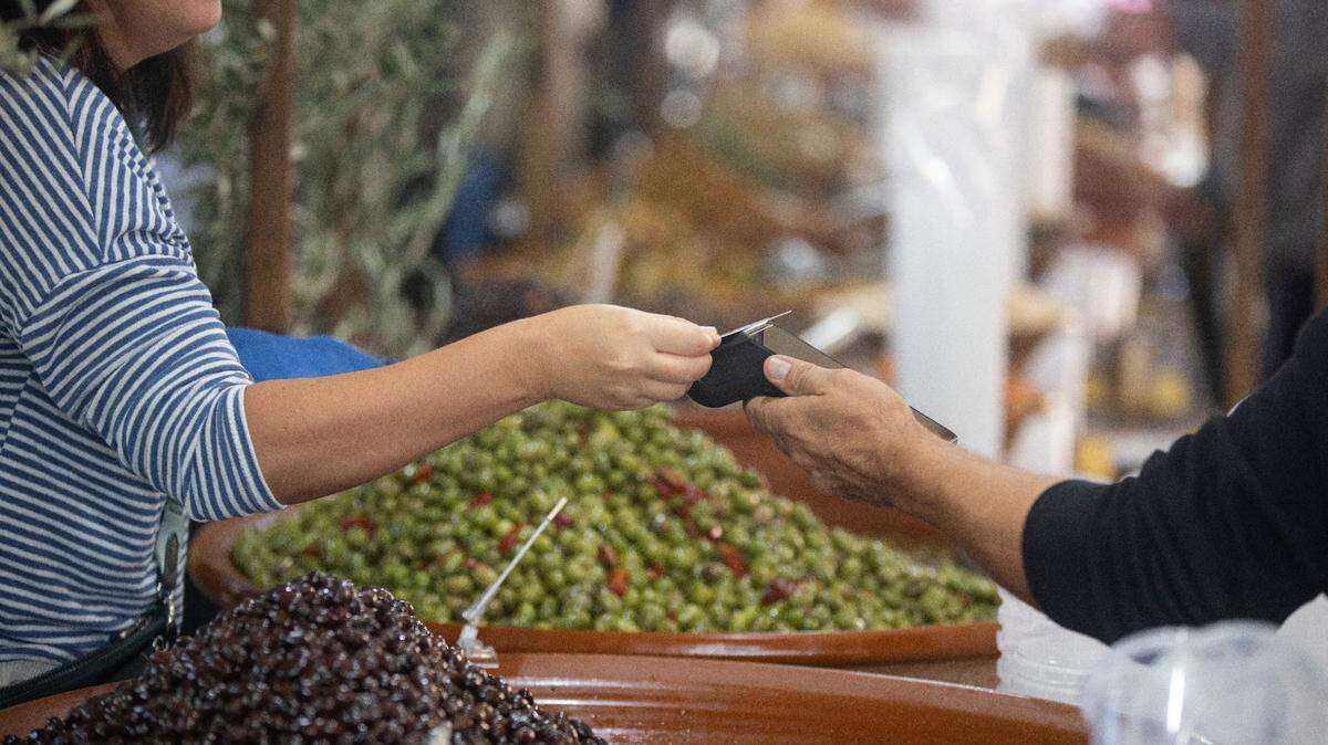Una mujer paga con una tarjeta de crédito en un mercado de aceitunas en el pueblo de Caimari, España, el 17 de noviembre de 2024.