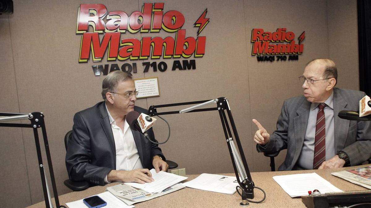 Las personalidades radiales Oscar Haza, a la izquierda, y Armando Pérez Roura, a la derecha, discuten eventos diarios en un programa de Radio Mambí transmitido el 4 de julio de 2012, en los Estudios Univision Radio, en Miami.