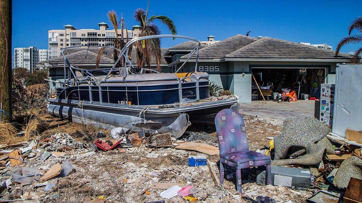 Un barco pontón y artículos para el hogar dañados, incluyendo refrigeradores y muebles, son depositados en Lagoon Road en Fort Myers Beach, el miércoles 27 de octubre de 2022. Retirar los escombros es parte del enorme esfuerzo de limpieza en curso desde que el huracán Ian golpeó la zona como una tormenta de categoría 4 el miércoles 28 de septiembre de 2022.