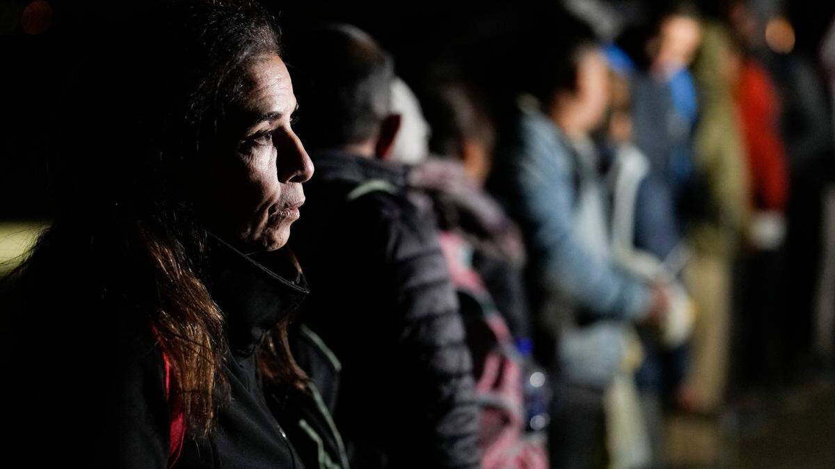 A Cuban woman waits with other migrants to be processed to seek asylum after crossing the border into the United States, Friday, Jan. 6, 2023, near Yuma, Arizona.