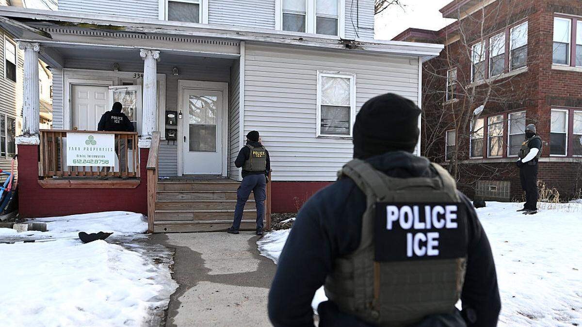 Foto de archivo de agentes de inmigración acercándose a una casa antes de detener a dos personas en Minneapolis, Minnesota. 