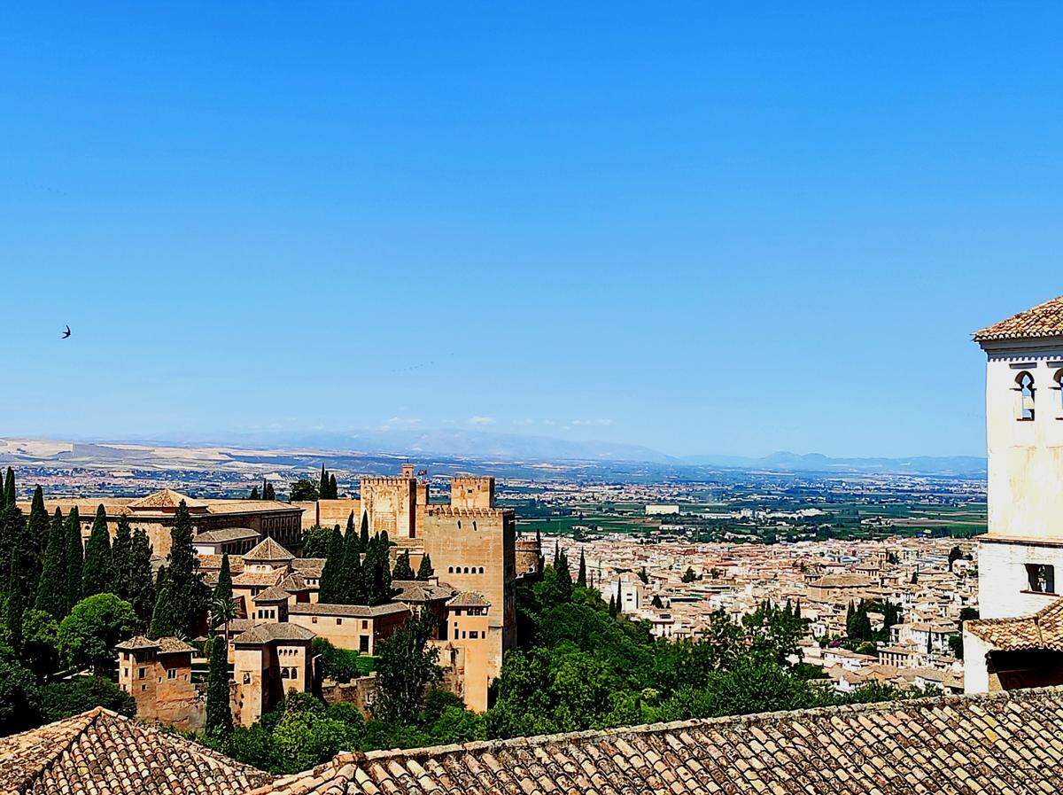 Vistas de la ciudad palatina de la Alhambra, con la ciudad de Granada al fondo, desde los jardines del Generalife, villa de recreo de los monarcas nazaríes ubicada tras los muros de la Alhambra.