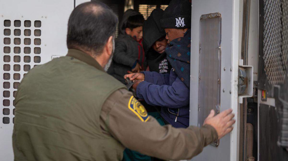 Foto de archivo del 20 de enero de 2025 que muestra a un agente de la Patrulla Fronteriza ayudando a transportar a varios inmigrantes cerca de Sasabe, Arizona.