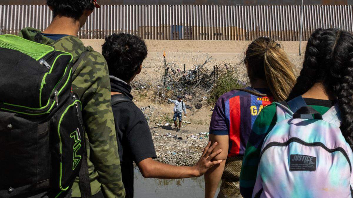 Un grupo de inmigrantes en Ciudad Juárez, México, observa la frontera con El Paso, Texas, el 6 de marzo de 2024.