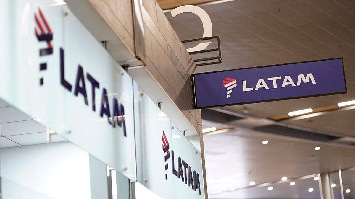 The Latam Airlines logo is pictured at El Dorado airport in Bogota on November 28, 2025. The International Air Transport Association (IATA) urged Venezuela on November 27 to "reconsider" the revocation of concessions for six airlines that canceled their flights following a security alert issued by the United States. The measure affected Spain's Iberia, Portugal's TAP, Colombia's Avianca, the Colombian subsidiary of Chilean-Brazilian Latam, Brazil's GOL and Turkey's Turkish Airlines, which had suspended their connections with Venezuela after Washington issued an alert over military activity in the southern Caribbean. (Photo by Sergio Yate / AFP via Getty Images)