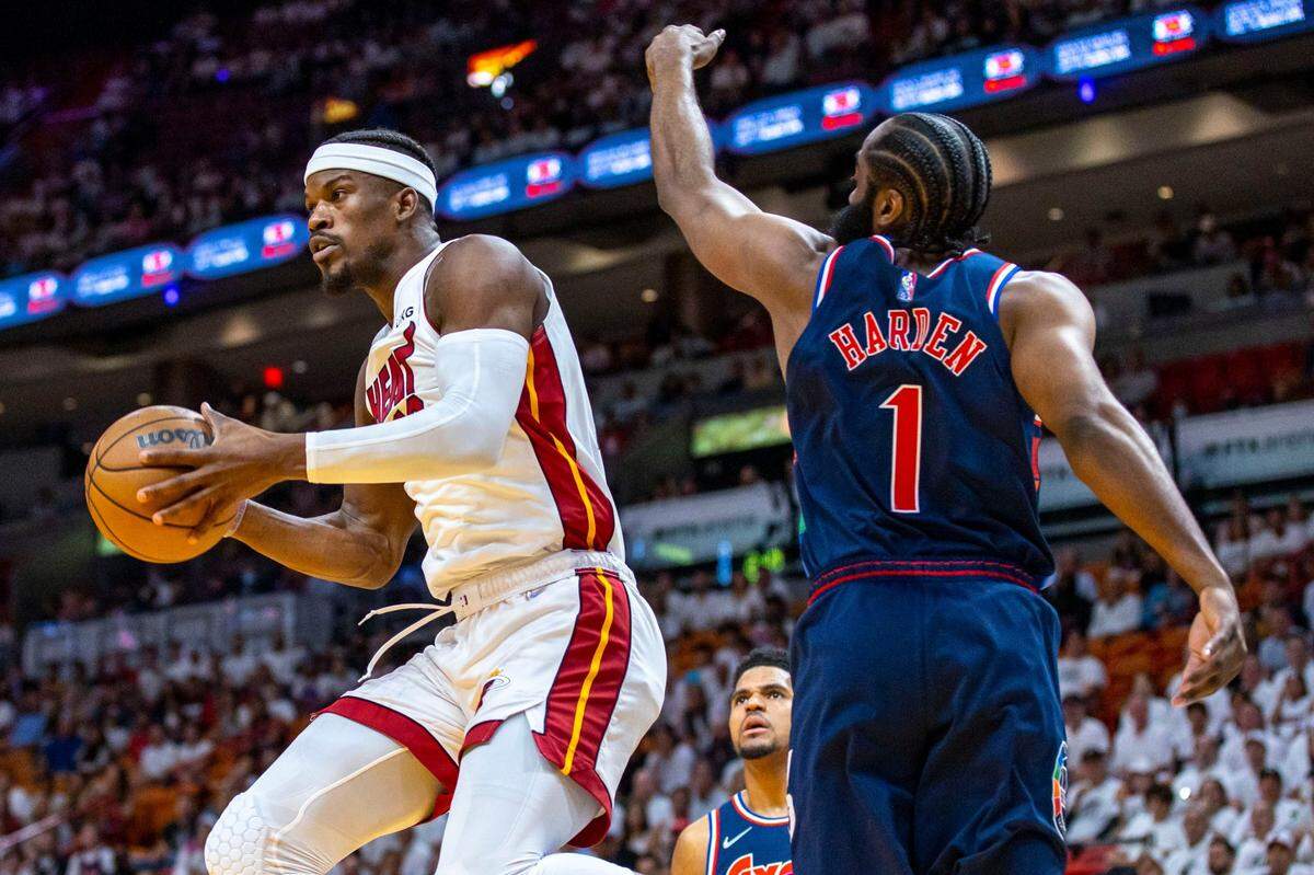 El jugador del Heat Jimmy Butler (izq.) controla un pase ante la marca de James Harden, de los 76ers de Filadelfia, en el partido inicial de la serie de segunda ronda de los playoffs de la NBA, celebrado el 2 de mayo de 2022 en Miami.