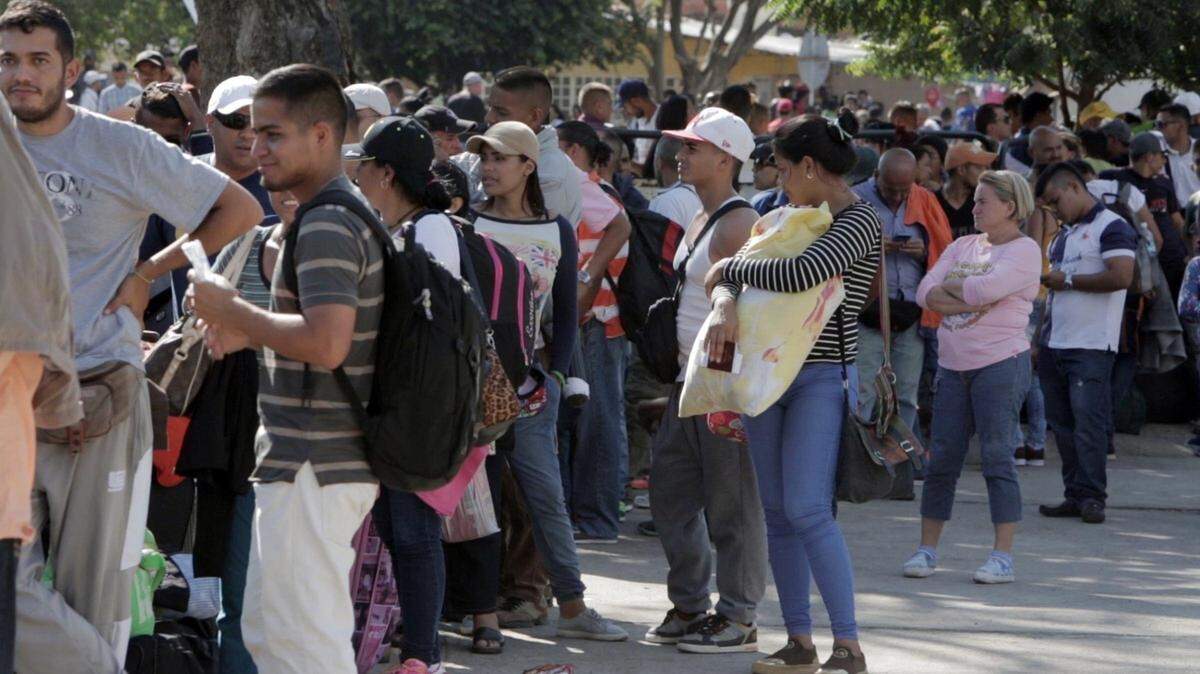 Venezolanos inmigrantes esperan en fila para cruzar el puente internacional Simón Bolívar en Cúcuta, Colombia, el 29 de enero de  2018