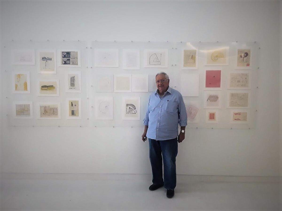 César Segnini frente a mural con dibujos de Ramírez Villamizar.
