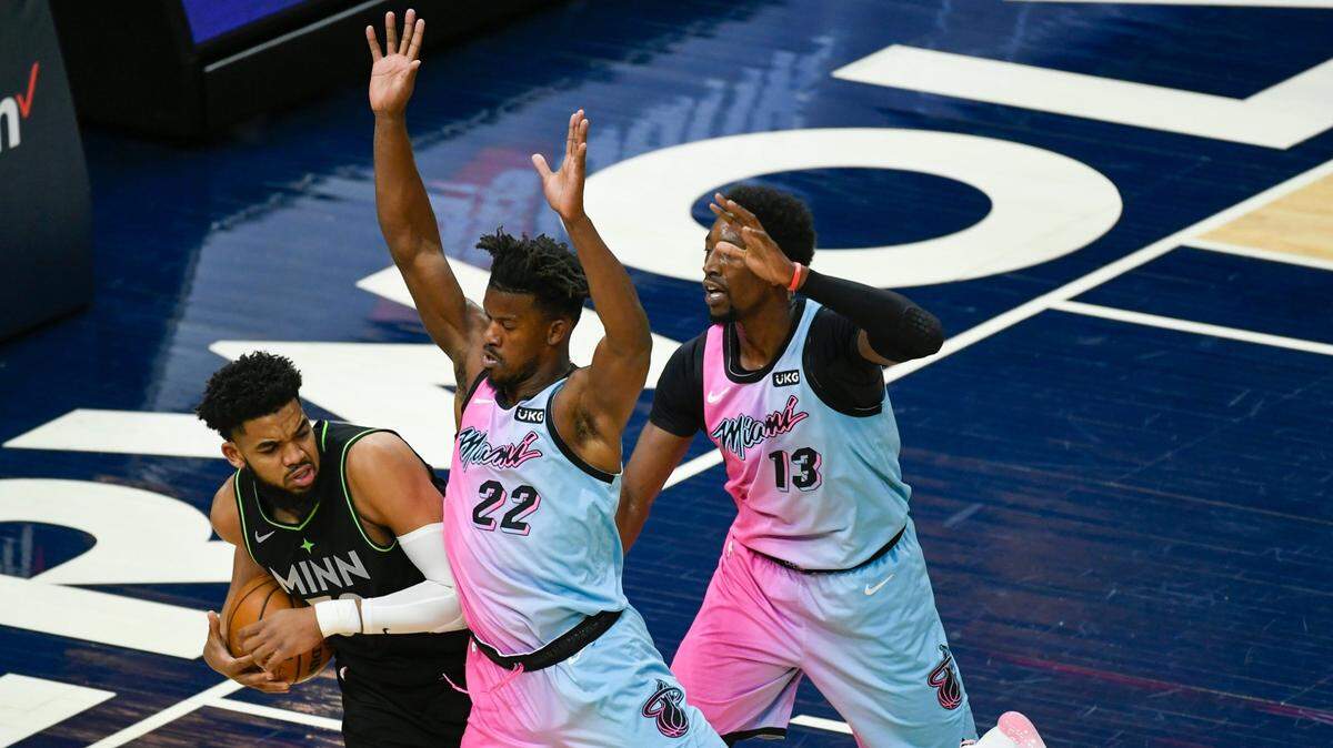El delantero del Heat Jimmy Butler (22) y el centro Bam Adebayo (13) marcan al centro los Timberwolves, Karl-Anthony Towns el viernes 16 de abril de 2021 en Minneapolis.