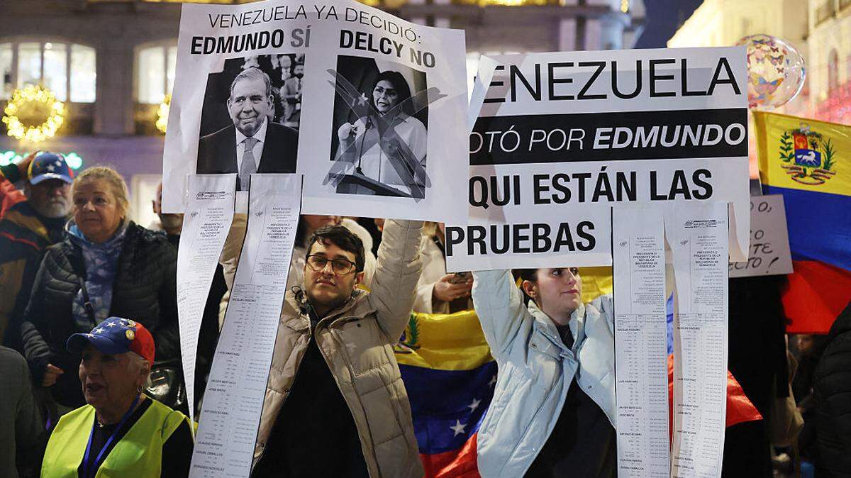 Manifestantes sostienen pancartas en apoyo al líder opositor venezolano Edmundo González Urrutia y en contra de la presidenta interina Delcy Rodríguez, durante una protesta el 4 de enero de 2026, en Madrid, España, al día siguiente de la captura de Nicolás Maduro.