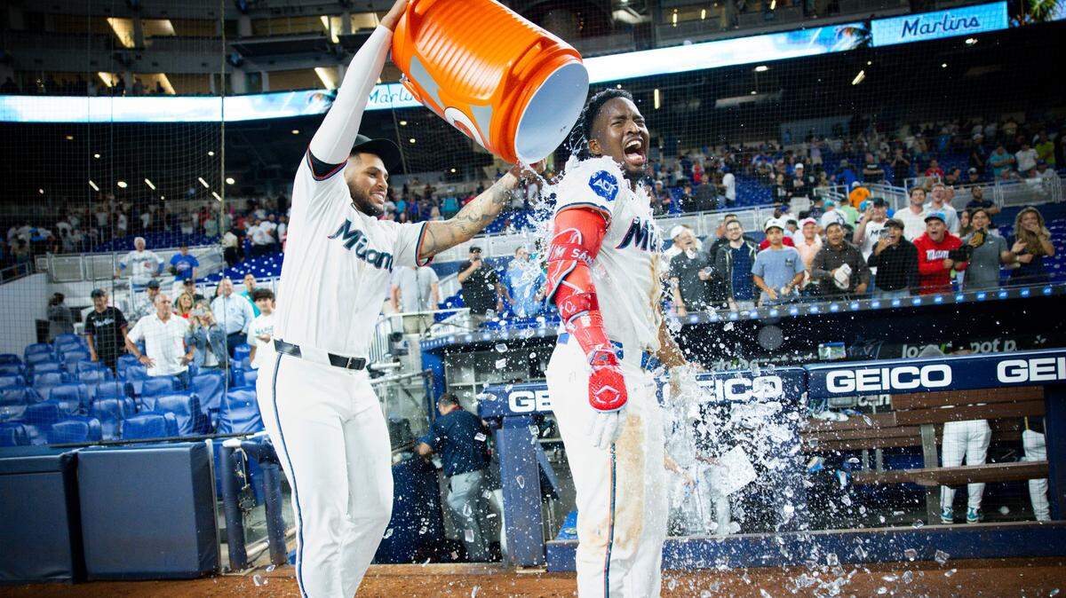 El bateador designado de los Marlins Agustín Ramírez vierte agua sobre el jardinero Jesús Sánchez, quien conectó el hit en la décima entrada que decidió el triunfo ante los Dodgers de Los Angeles, en el partido celebrado el 6 de mayo de 2025 en loanDepot Park en Miami.
