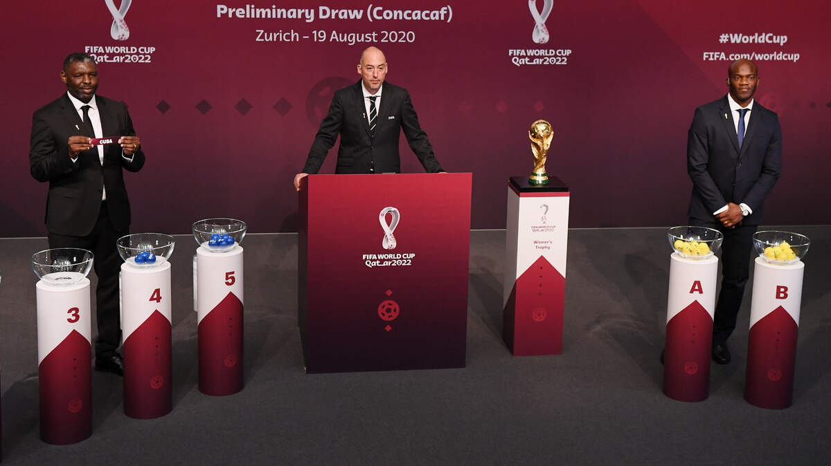 Shaun Goater, de Bermudas y leyenda del Manchester City, muestra el nombre de Cuba en el sorteo del miércoles 19 de agosto del 2020 para las eliminatorias de la CONCACAF al Mundial de Catar 2022. Al centro el jefe de torneos de la FIFA Jaime Yarza y a la derecha el ídolo hondureño David Suazo.