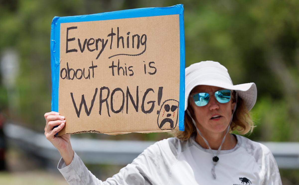 Angel Obrochta protesta frente a Alligator Alcatraz mientras legisladores y congresistas de Florida recorren las instalaciones en los Everglades de Florida. El centro de detención se encuentra a 58 kilómetros al oeste del distrito financiero de Miami, en el condado de Collier, Florida, el sábado 12 de julio de 2025. 