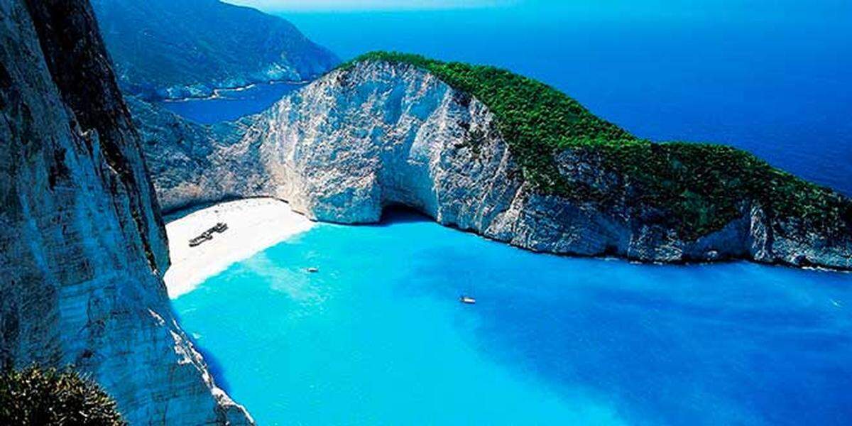 La isla jónica de Zante se ha hecho conocida por sus increíbles playas. La más famosa, la de Navagio debe su nombre al naufragio de un barco cargado de tabaco de contrabando. Hoy los restos de aquel naufragio, de 1983, permanecen semienterrados en la arena.