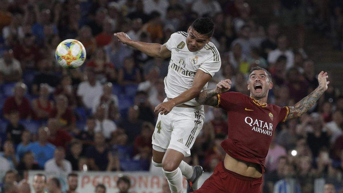 El jugador de Real Madrid Casemiro (izq.) lucha por la pelota con Aleksandar Kolarov, de la Roma en el partido efectuado el 11 de agosto de 2019 en Roma.