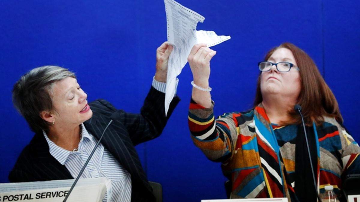La presidenta de la junta de supervisión electoral, Betsy Benson, izquierda, junto a la jueza Deborah Carpenter-Toye, muentran a los abogados unas boletas en Broward el 14 de noviembre.